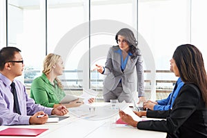 Businesswoman Conducting Meeting In Boardroom