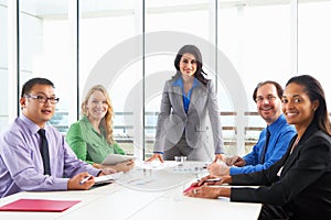 Businesswoman Conducting Meeting In Boardroom