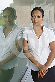 Businesswoman Contemplating While Leaning On Glass