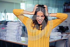 Businesswoman covering her ears and shouting