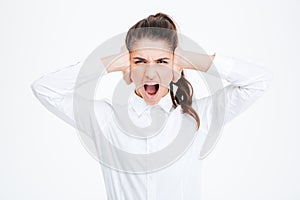 Businesswoman covering her ears and shouting over white background