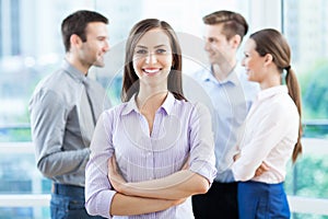 Businesswoman with coworkers in background photo