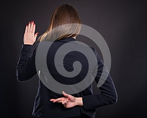 Businesswoman with crossed fingers behind her back