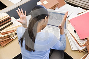 Businesswoman in cubicle with laptop