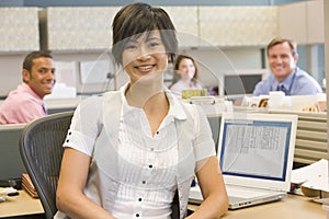 Businesswoman in cubicle smiling