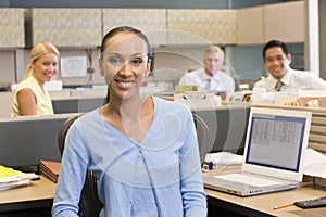 Businesswoman in cubicle smiling