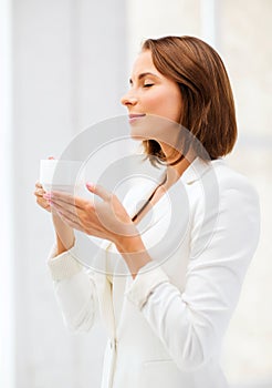 Businesswoman with cup of coffee in office photo