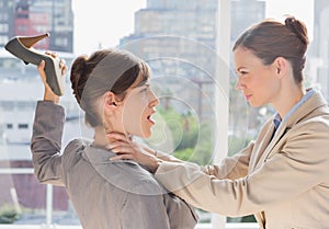 Businesswoman defending herself from her co worker strangling her