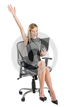 Businesswoman With Digital Tablet Celebrating Success While Sitting On Chair