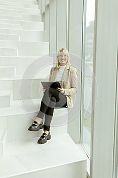 Businesswoman with digital tablet on modern office stairs