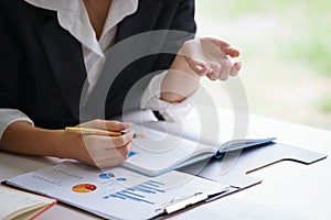 Businesswoman discussing a financial plan with financial document graph in meeting room