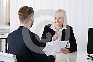 Businesswoman Discussing Over Resume With Male Candidate