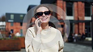 Businesswoman discussing plans during phone call while walking in public place