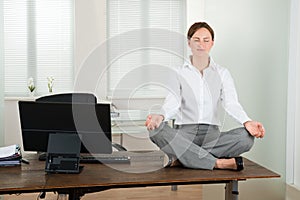 Businesswoman Doing Yoga In Office