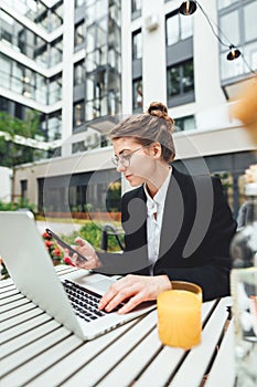 Businesswoman drinking coffee at cafe and hold smartphone