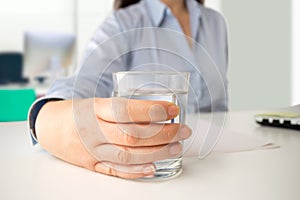 Businesswoman drinking water at office photo