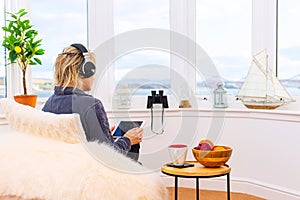 Businesswoman with earphones working from home with notepad