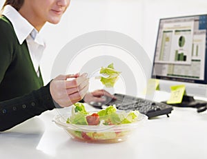 Businesswoman eating salad