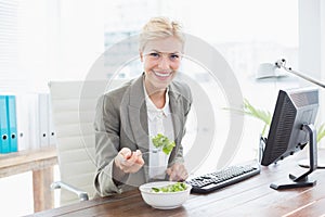 Businesswoman eating salad on her desk