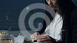 Businesswoman eating at workplace.Young woman in a modern beautiful office near the panoramic window dines and examines