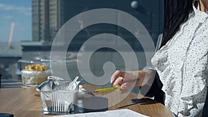 Businesswoman eating at workplace.Young woman in a modern beautiful office near the panoramic window dines and examines