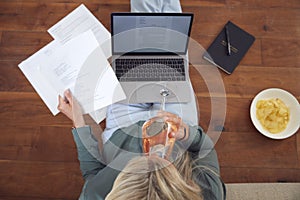 Businesswoman At End Of Day With Wine Wearing Loungewear And Suit On Laptop Working From Home photo