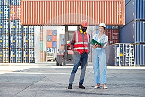 Businesswoman and engineer talking and checking loading Containers box from Cargo freight ship for import export. shipping in