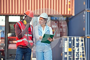 Businesswoman and engineer talking and checking loading Containers box from Cargo freight ship for import export. shipping in