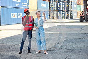 Businesswoman and engineer talking and checking loading Containers box from Cargo freight ship for import export. shipping in