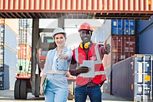 Businesswoman and engnineer showing thumbs up with laptop working at warehouse container cargo ship import export industry