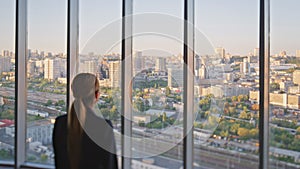 Businesswoman enjoying city view in office. Pensive concerned manager looking