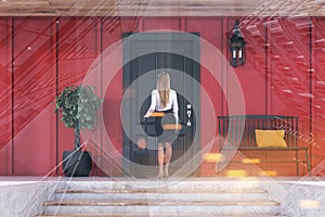 Businesswoman entering black door of red house