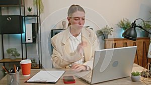 Businesswoman enters office start working on laptop computer at desk and drinking morning coffee