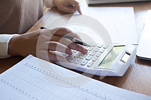 Businesswoman, entrepreneur, accountant working on financial report on desk using calculator, laptop.
