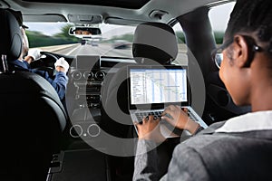 Businesswoman Examining Gantt Chart While Traveling By Car