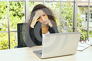 Business woman sitting in office with stress migraine headache. photo