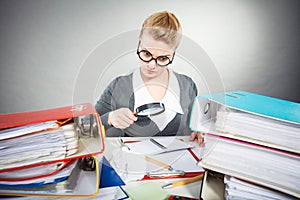 Businesswoman explore documents with big loupe.