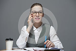 A businesswoman in eyeglasses making a call
