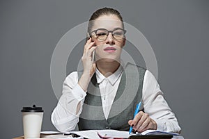 A businesswoman in eyeglasses making a call