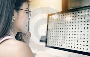 Geschäftsfrau Gläser auf der ihr Arbeitsplatz a sieht an bildschirm 