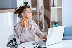 Businesswoman feeling pain in neck after sitting at the table with laptop. Tired female suffering of office syndrome because of