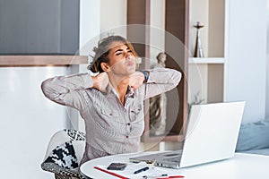 Businesswoman feeling pain in neck after sitting at the table with laptop. Tired female suffering of office syndrome because of