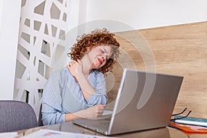 Businesswoman feeling pain in neck after sitting at the table with laptop. Tired female suffering of office syndrome because of