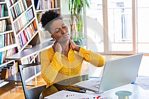 Businesswoman feeling pain in neck after sitting at the table with laptop. Tired female suffering of office syndrome because of