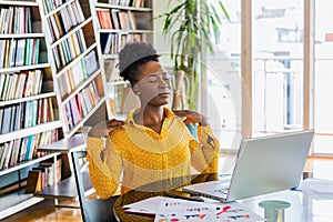 Businesswoman feeling pain in neck after sitting at the table with laptop. Tired female suffering of office syndrome because of