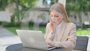 Businesswoman Feeling Shock while using Laptop in Outdoor Cafe