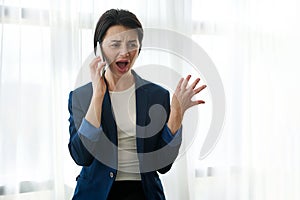 Businesswoman, female employee, young entrepreneur swears, argues, gestures with her hands while talking on the phone