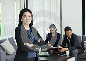 Businesswoman female leader standing and cross arm with team in