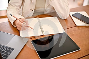 A businesswoman or female office employee listing her work list on a notebook