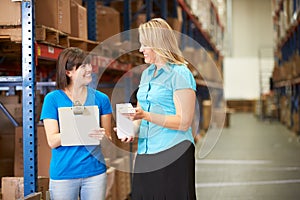 Businesswoman And Female Worker In Distribution Warehouse